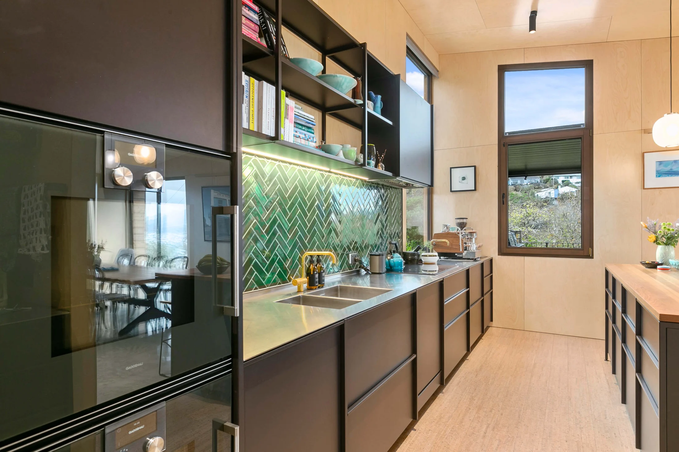 Custom kitchen with green tiled splashback, timber joinery and warm brass fittings